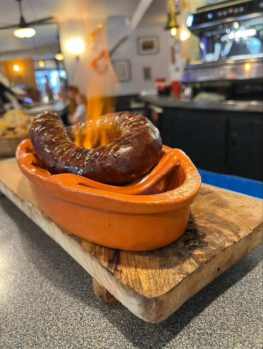 Chouriço flambé servi dans son plat en terre cuite