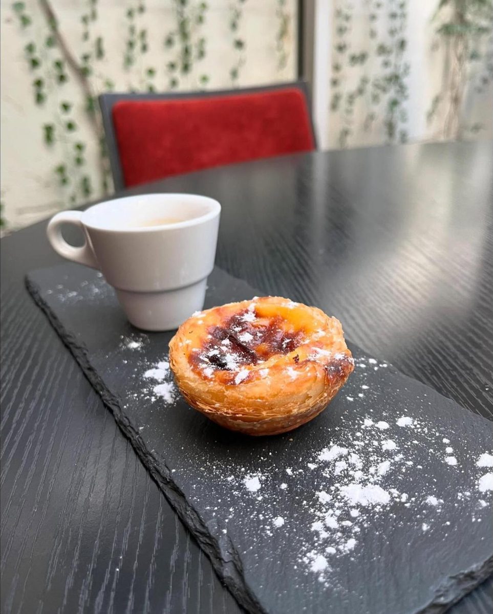 Pastel de nata saupoudré de sucre glace sur ardoise