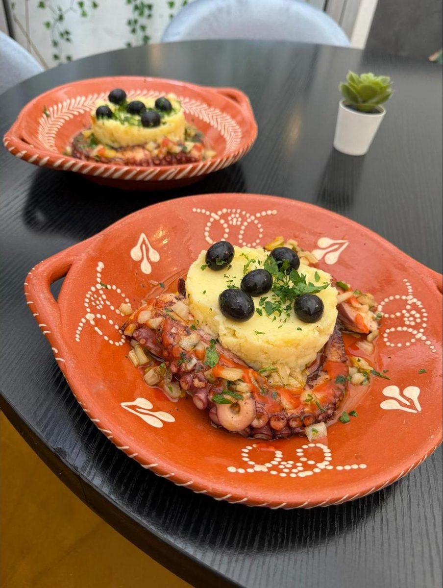 Poulpe grillé à la portugaise avec purée et olives dans un plat en terre cuite