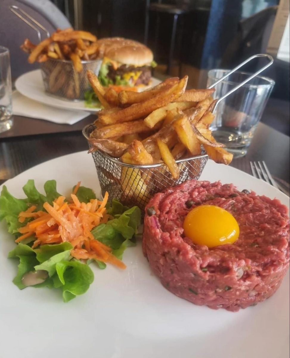 Tartare de bœuf coupé au couteau avec jaune d'œuf et salade